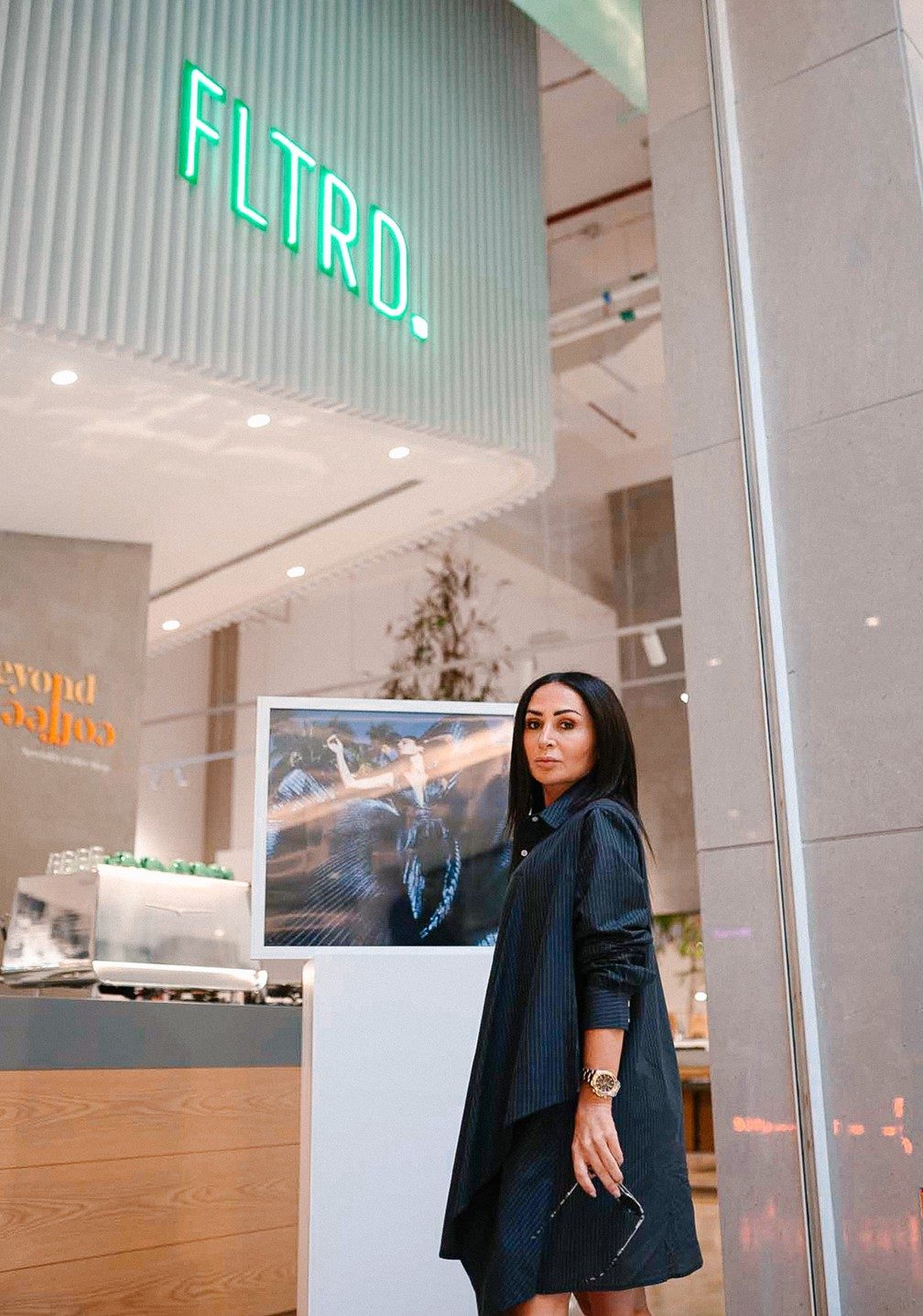 Fashion designer and entrepreneur Zeina Ladki standing next to her brand, fltrd